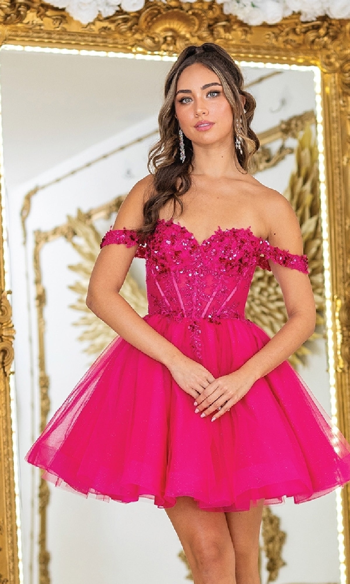 Woman wearing a pink off-shoulder dress with a gold framed mirror in the background